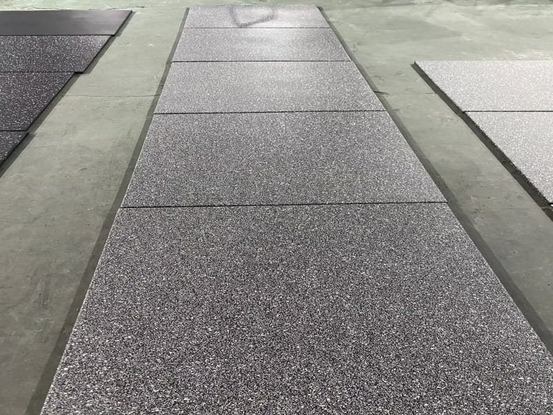 Ein Spielplatz, der zur Hälfte aus pflegeleichten Gummifliesen und zur anderen Hälfte aus pflegeintensivem Sand besteht, der geharkt werden muss.